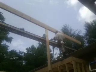 Carpenter setting a ridge beam over a new addition frame — Ice Dam Removal by Roofing Brothers in Doty