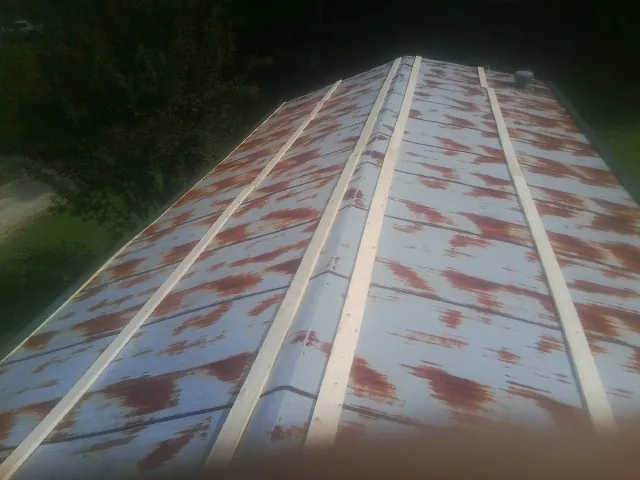 Rusted metal roof panels with new wood purlins before replacement — Storm Damage Roof Repair in Doty by Roofing Brothers