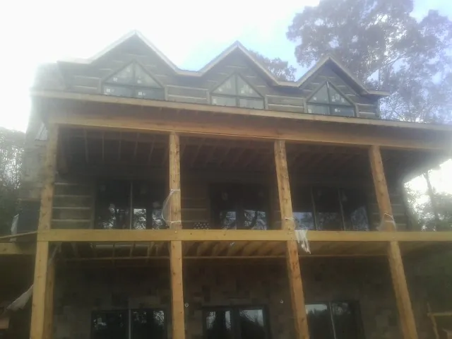 Dormers and porch framing on a large log home under construction — Roof Coating work by our crew in Doty