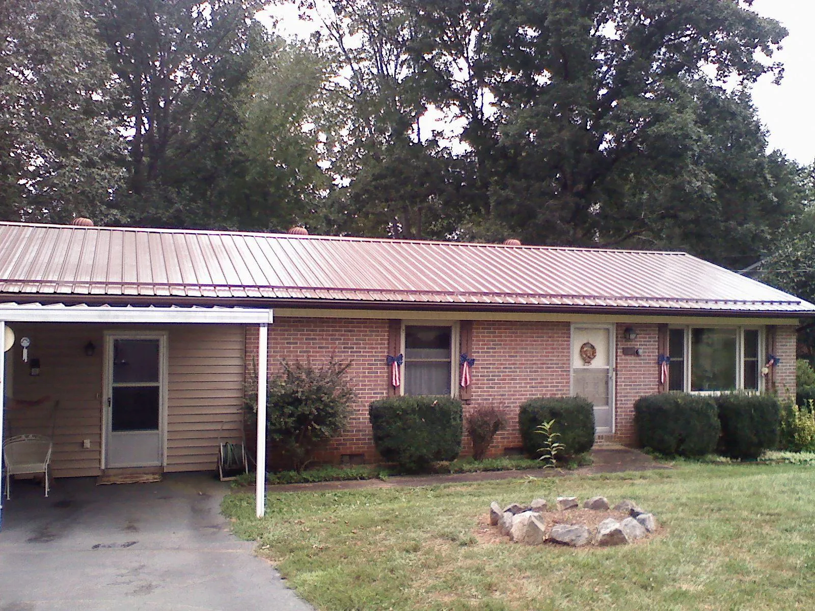 Bronze metal roof and carport on a brick ranch home — Roof Repair work by our crew in Doty